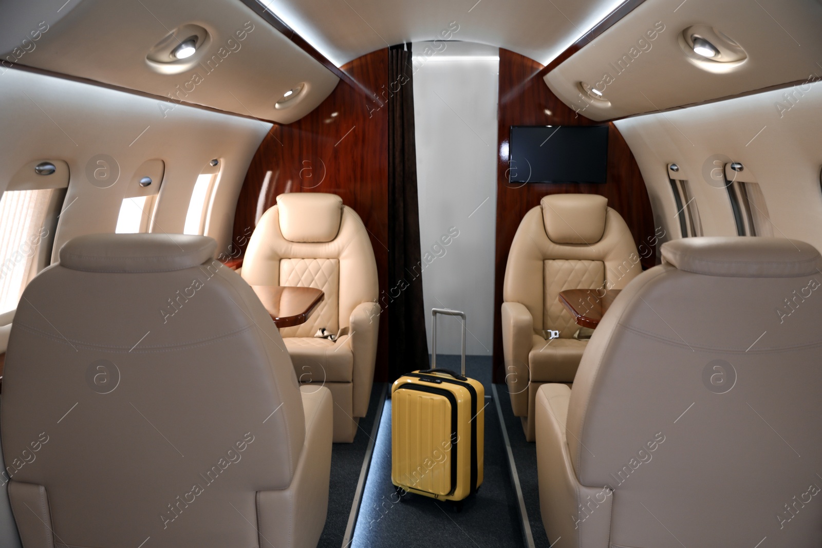 Image of Airplane cabin with yellow suitcase. Air travel