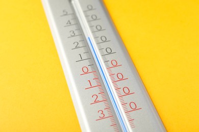 Photo of Modern weather thermometer on yellow background, closeup