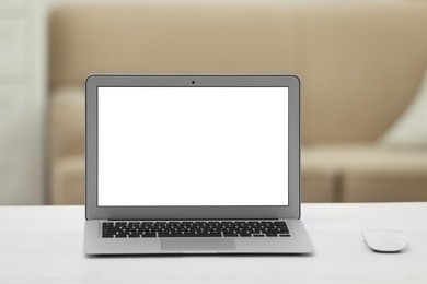 Photo of Laptop with blank screen on table indoors. Space for text