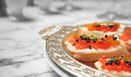 Photo of Sandwiches with black and red caviar on tray, closeup