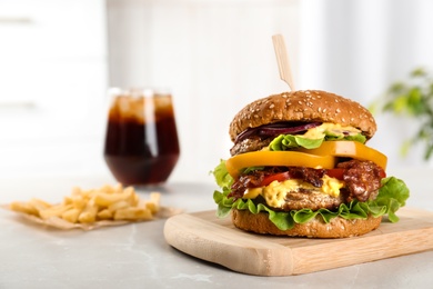 Photo of Board with tasty burger on table. Space for text