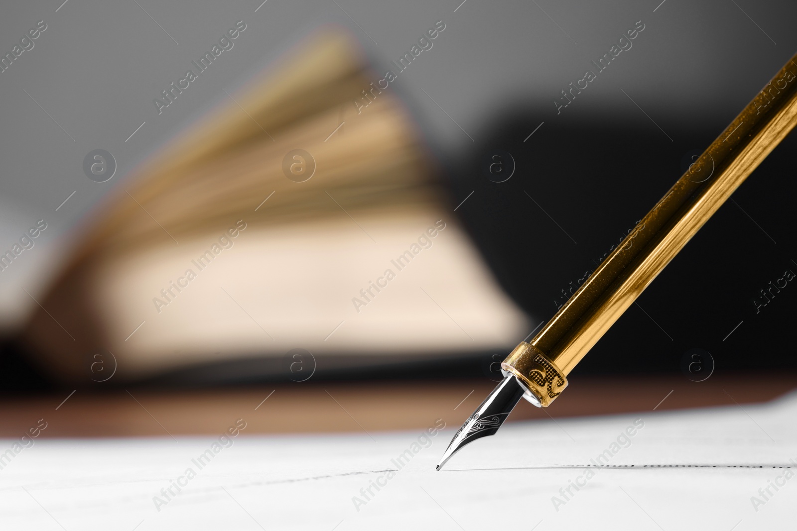 Photo of Writing on document with fountain pen at table, closeup and space for text. Notary contract