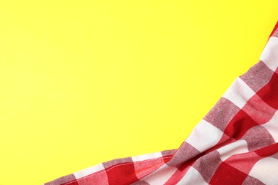 Photo of Checkered picnic blanket on color background, top view. Space for text