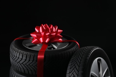 Gift set of wheels with winter tires on black background, closeup