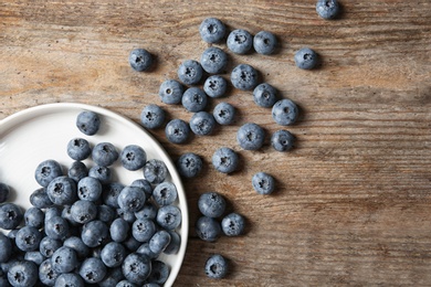 Photo of Flat lay composition with juicy and fresh blueberries on wooden table