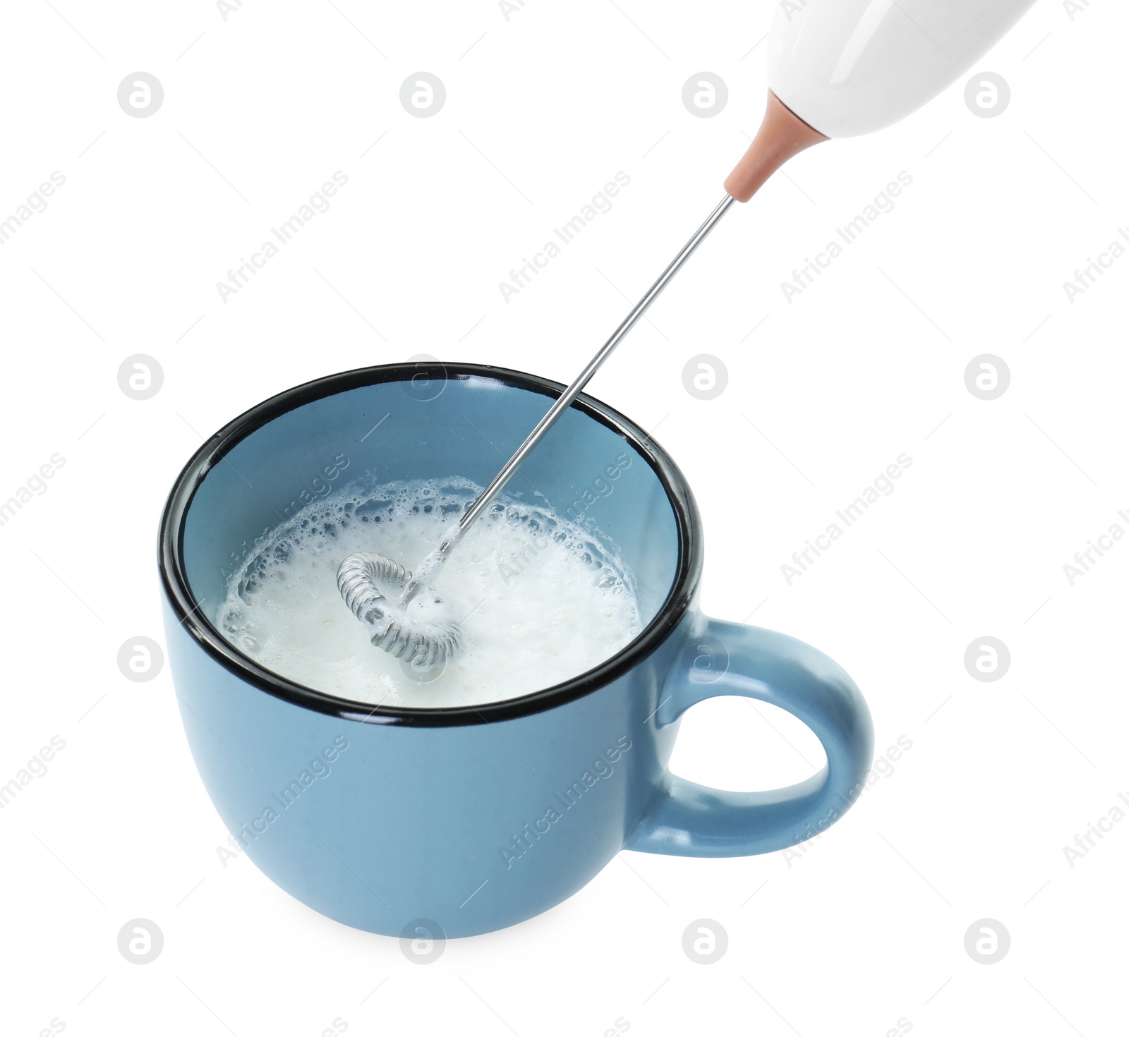 Photo of Whisking milk in cup with mini mixer (frother wand) isolated on white, closeup