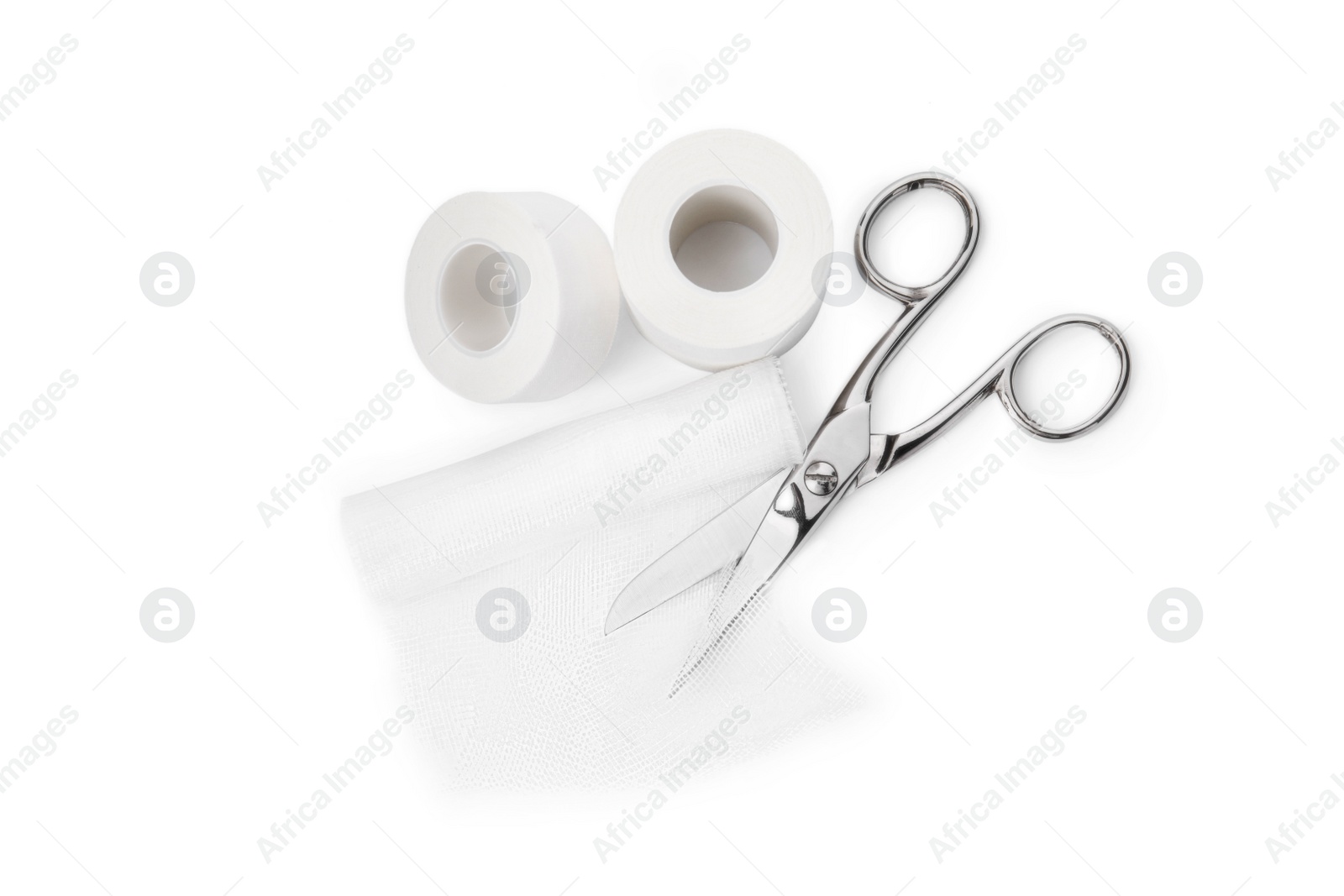 Photo of Medical bandage rolls, sticking plaster and scissors on white background, top view