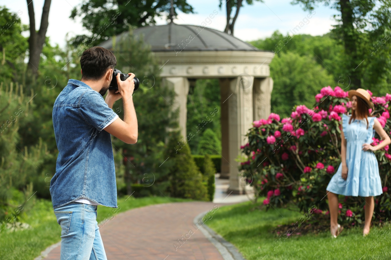 Photo of Photographer taking photo of woman with professional camera in park