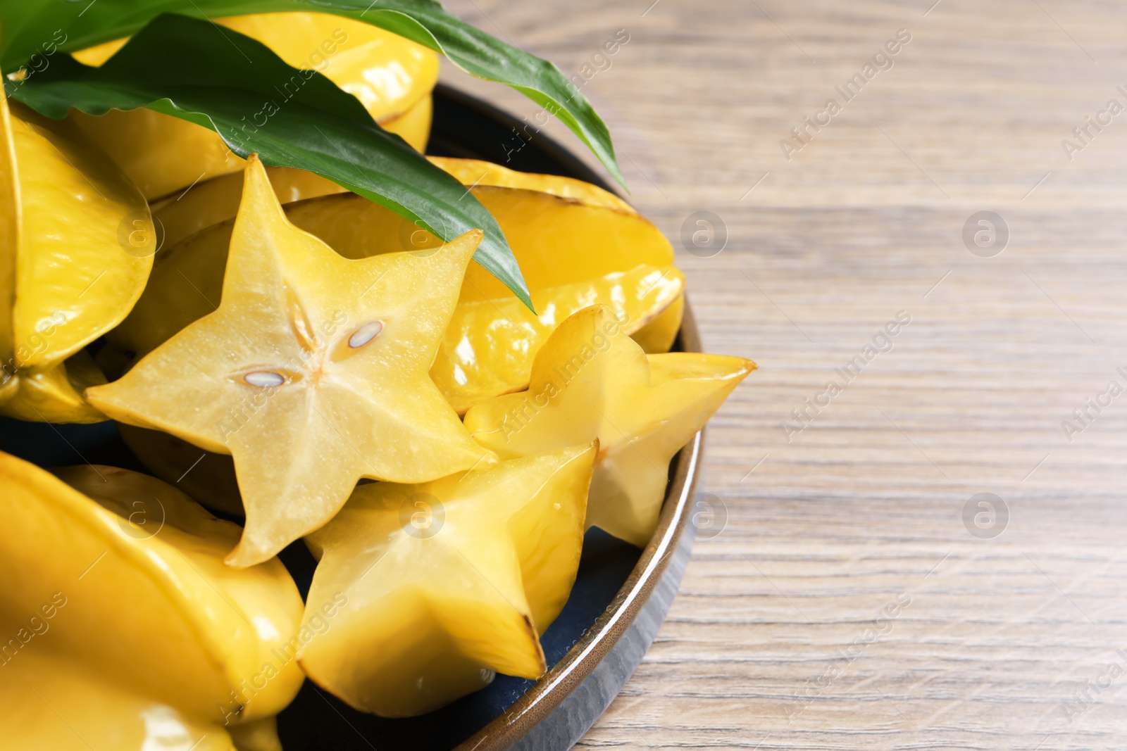 Photo of Delicious carambola fruits on wooden table, above view. Space for text