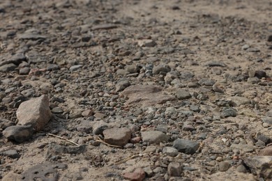 Photo of Dirt road with stones as background, closeup