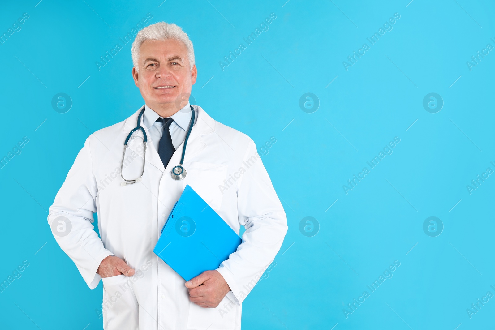 Photo of Portrait of senior doctor with clipboard against blue background, space for text