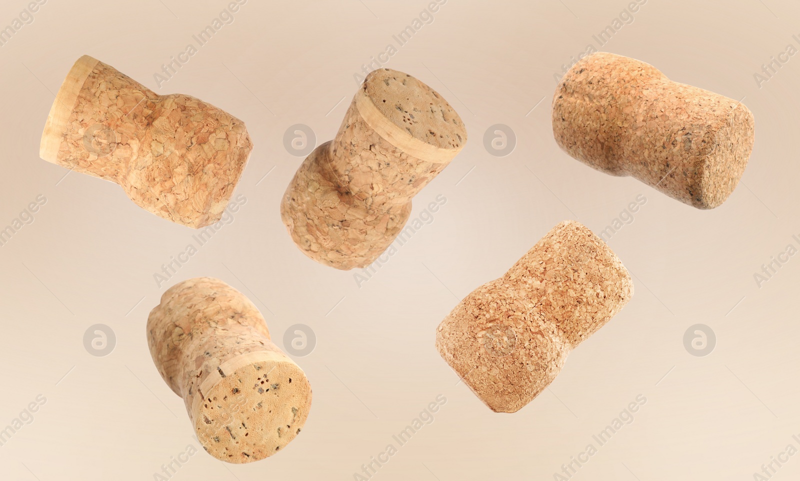 Image of Many corks of sparkling wine bottles falling on light background