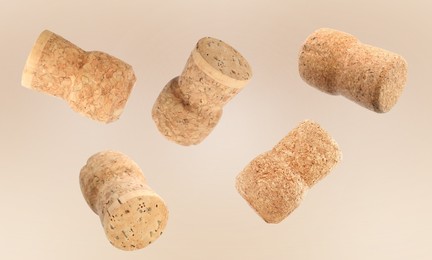 Image of Many corks of sparkling wine bottles falling on light background