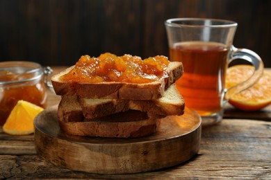 Photo of Delicious toasts with jam served on wooden table, closeup