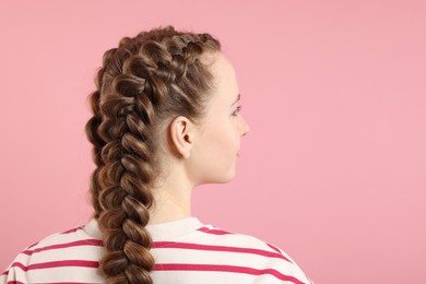 Photo of Woman with braided hair on pink background, space for text