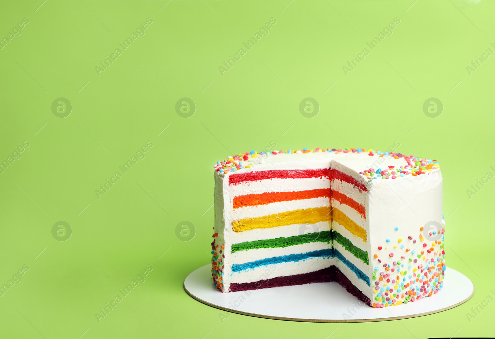 Photo of Delicious rainbow cake on color background