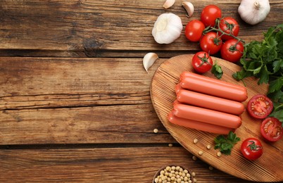 Fresh raw vegetarian sausages, soybeans and vegetable on wooden table, flat lay. Space for text