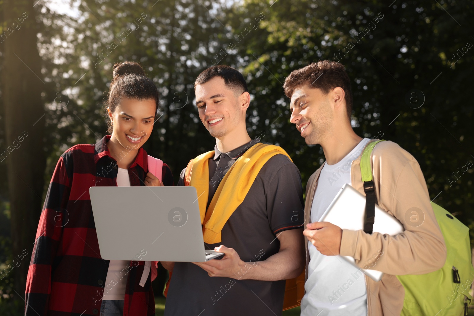 Photo of Happy young students spending time together in park