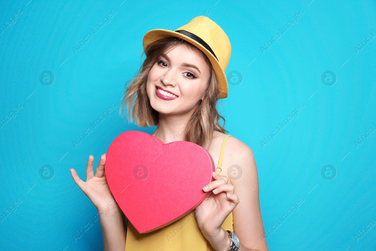 Photo of Beautiful young woman with pink heart posing on color background