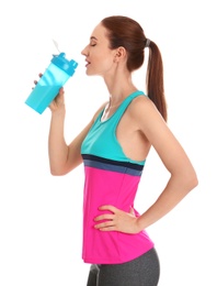 Athletic young woman drinking protein shake on white background