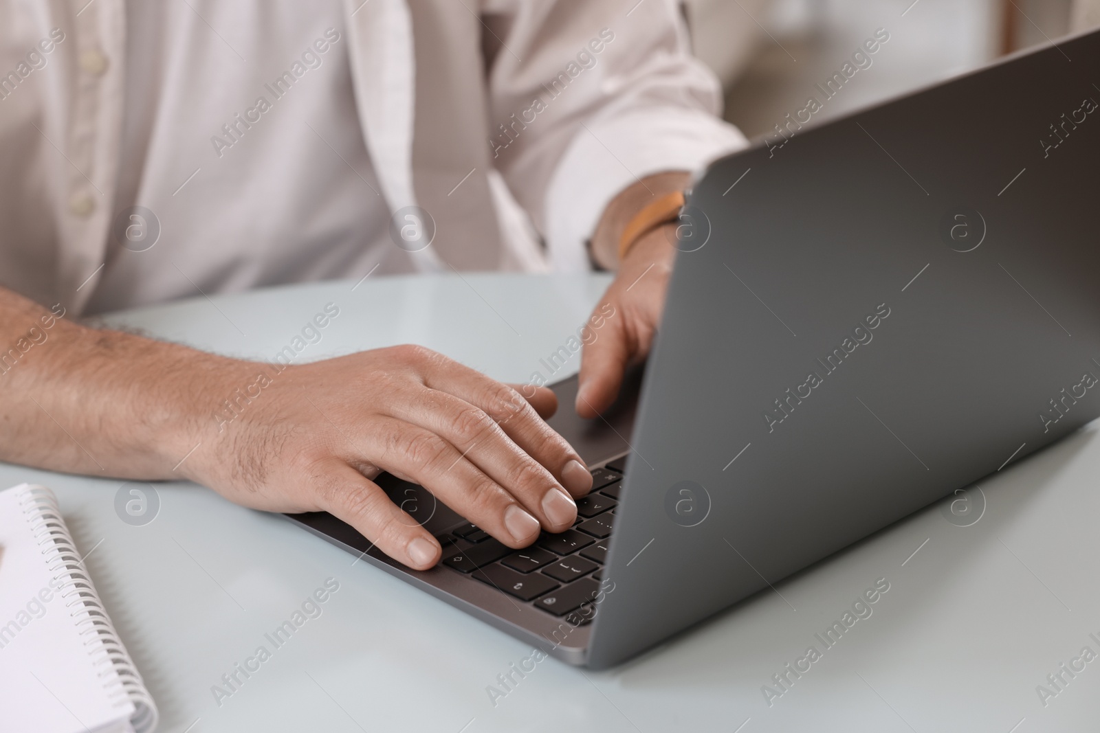 Photo of Man using modern laptop at table in cafe, closeup