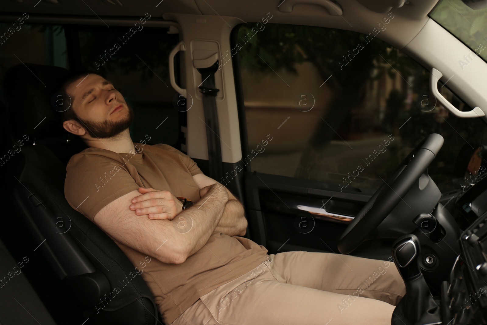 Photo of Tired man sleeping in his modern car