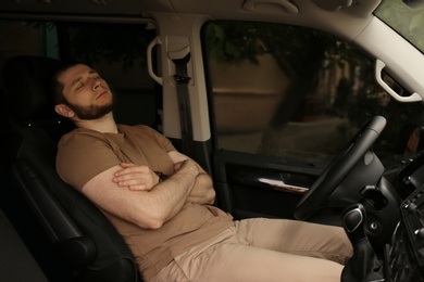 Tired man sleeping in his modern car