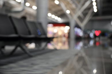 Photo of Blurred view of waiting area with seats in airport terminal