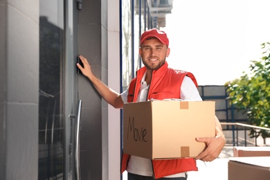 Male mover with parcel box near entrance