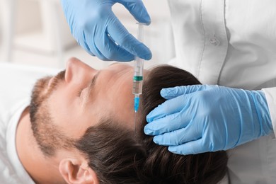 Photo of Trichologist giving injection to patient in clinic, closeup