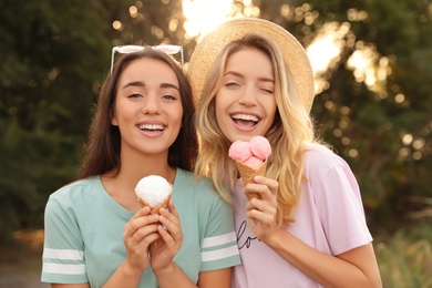 Photo of Young women with ice cream spending time together outdoors