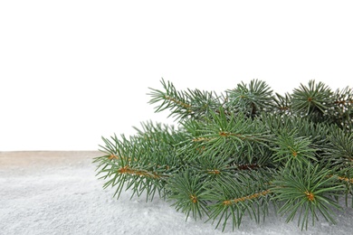 Christmas tree branches and snow on table against white background