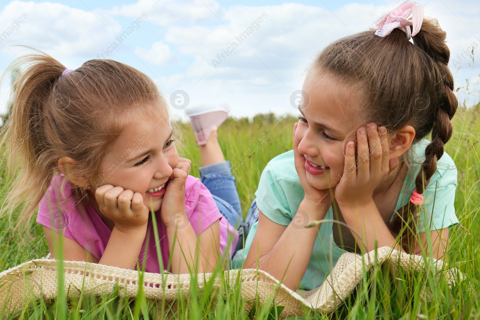 Photo of Cute happy girls on blanket in field