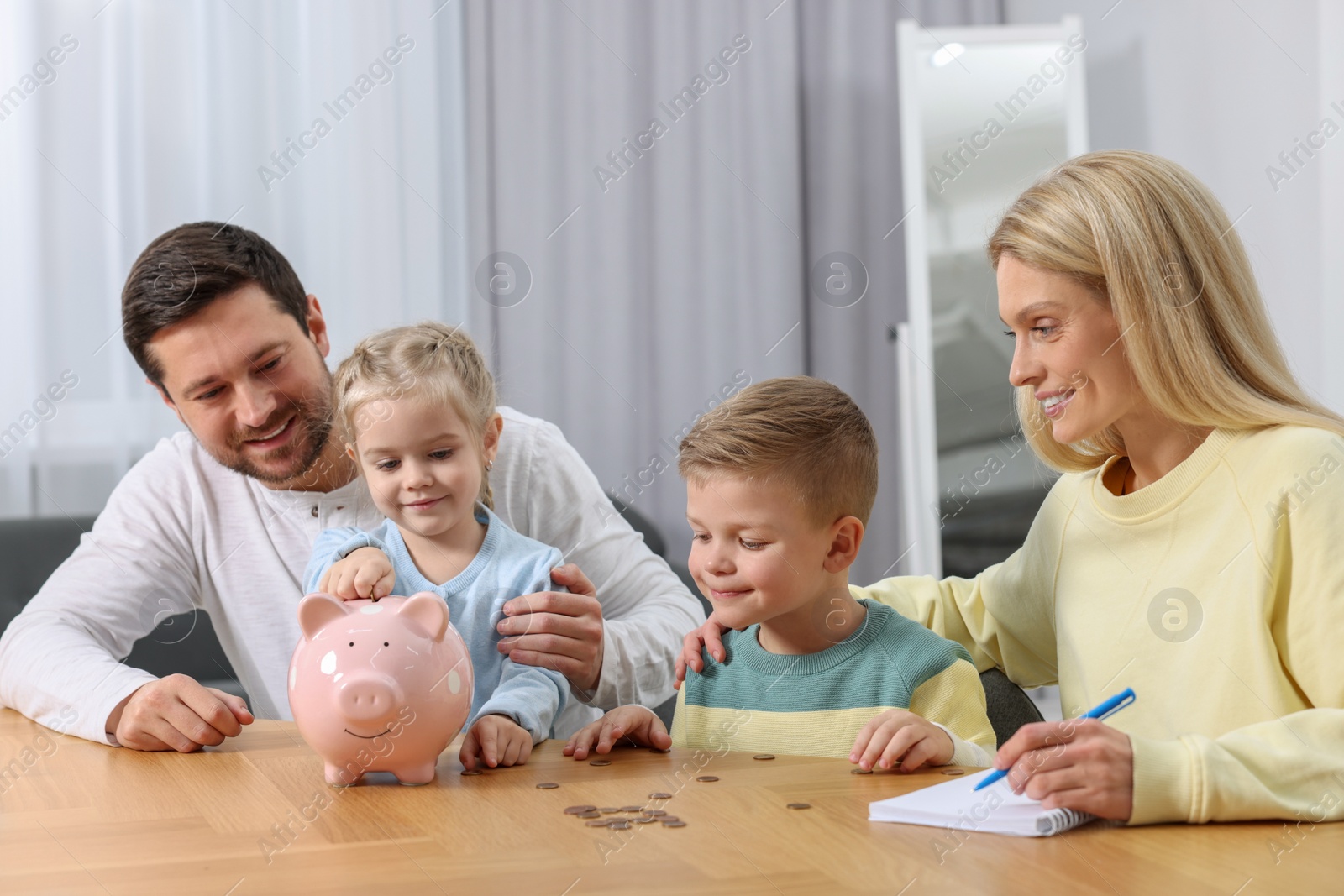 Photo of Planning budget together. Family with piggy bank and coins at home