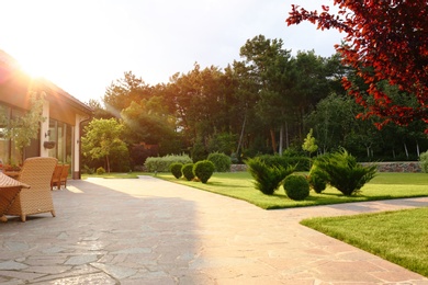 Photo of Picturesque landscape with beautiful green garden near house on sunny day