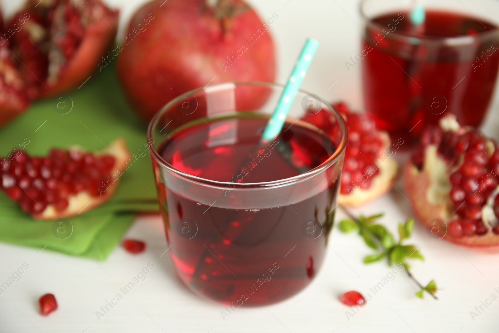 Photo of Pomegranate juice and fresh fruits on white table outdoors