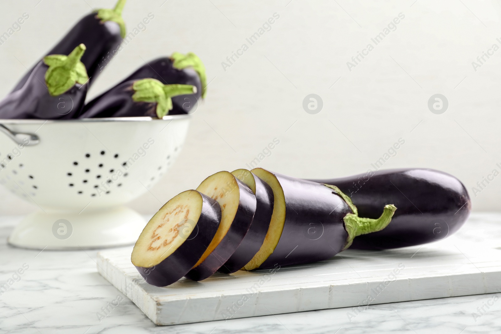 Photo of Wooden board with ripe eggplants on table