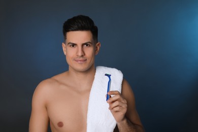 Photo of Handsome man with razor after shaving on blue background