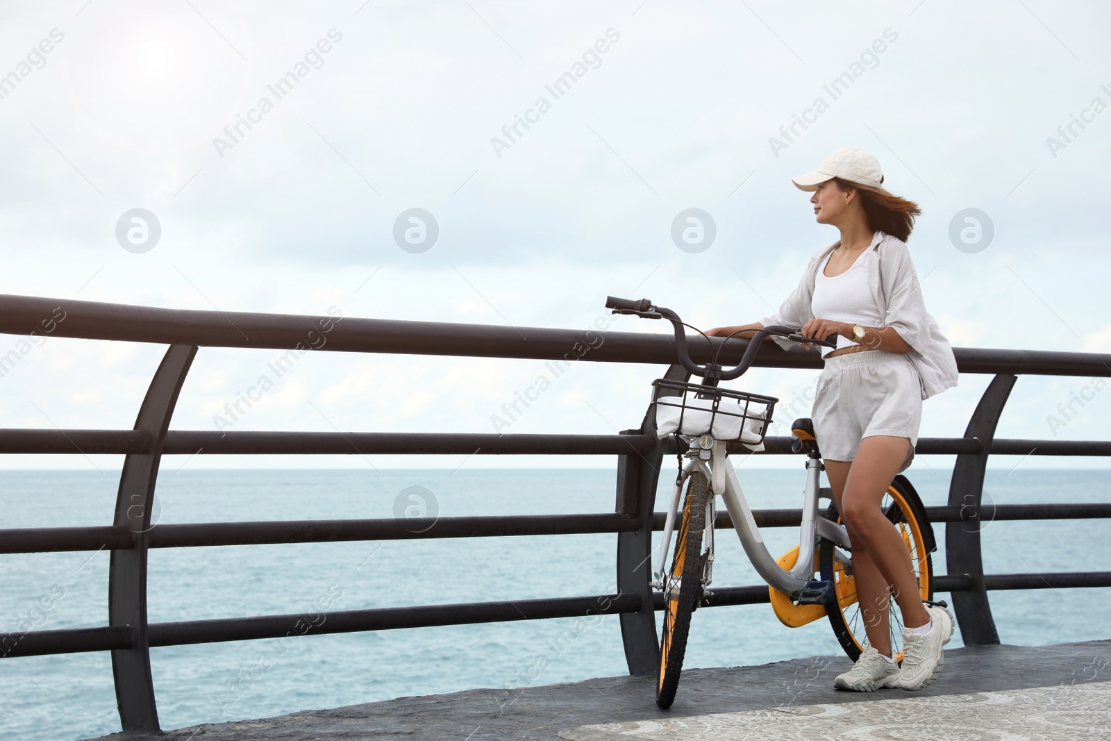 Photo of Beautiful young woman with bicycle near sea. Space for text