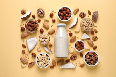 Photo of Vegan milk and different nuts on beige background, flat lay