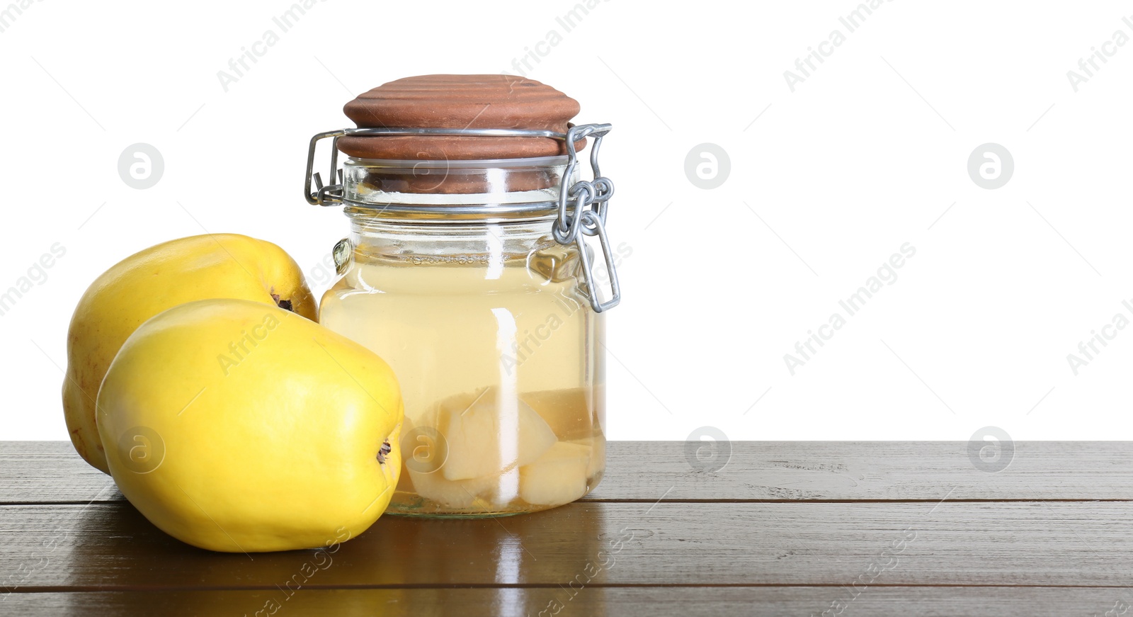 Photo of Delicious quince drink and fresh fruits on wooden table against white background