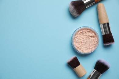 Photo of Face powder and makeup brushes on light blue background, flat lay. Space for text