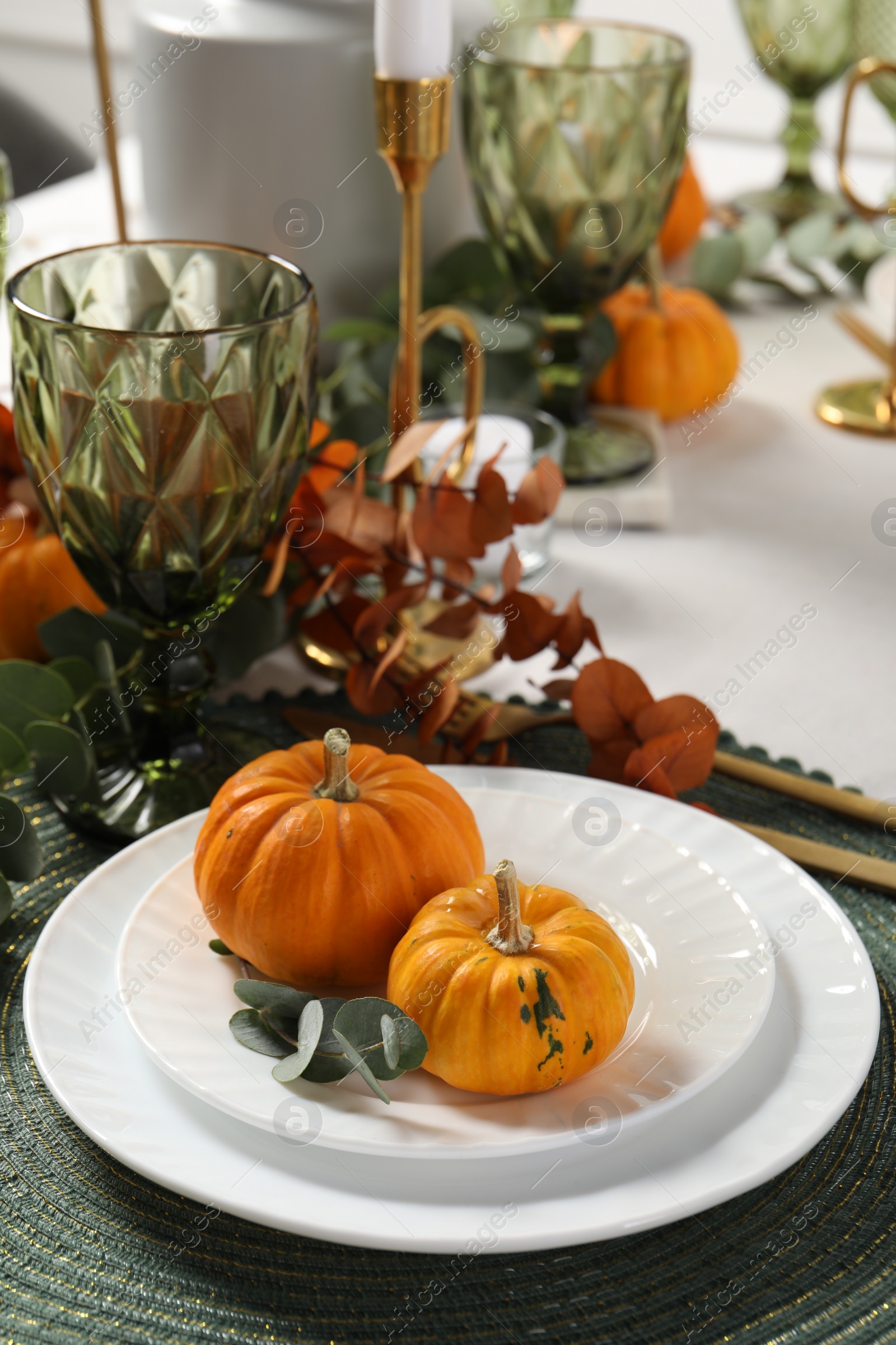 Photo of Beautiful autumn table setting. Plates, cutlery, glasses, pumpkins and floral decor