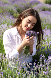 Young woman with lavender bouquet in field on summer day