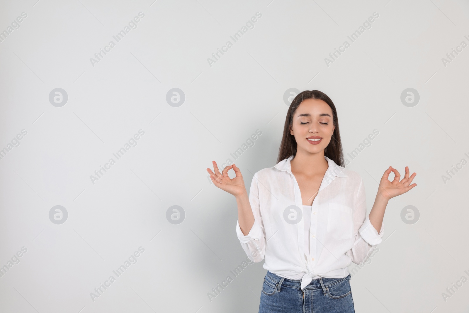 Photo of Find zen. Beautiful young woman meditating on white background. Space for text