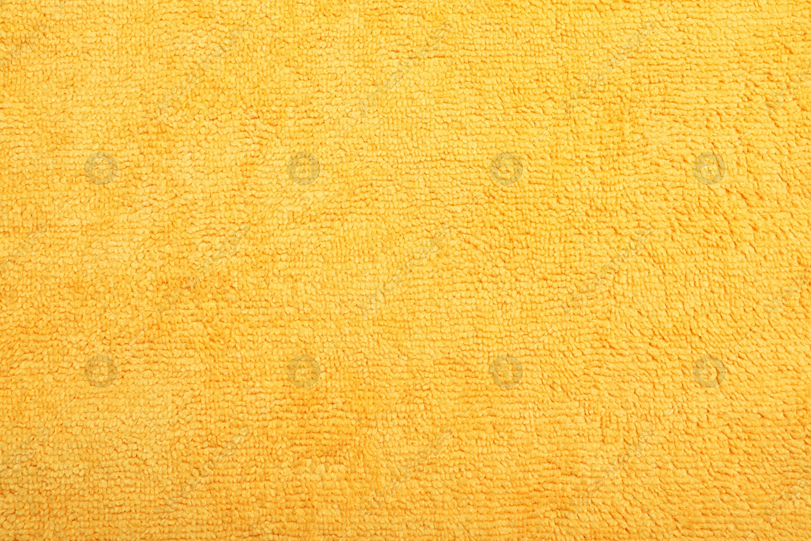 Photo of Orange microfiber cloth as background, top view