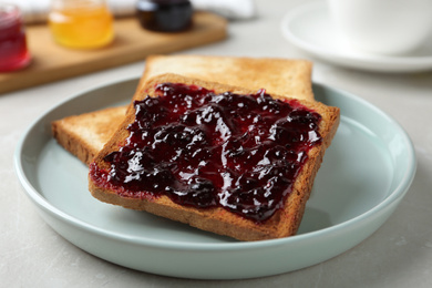 Delicious crispy toasts with jam on table, closeup