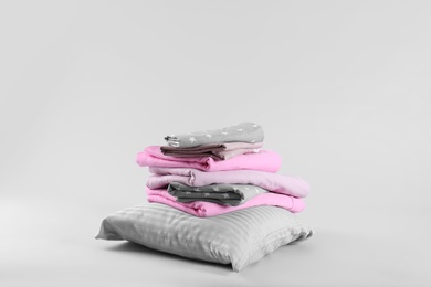 Photo of Stack of clean bed sheets and pillow on white background