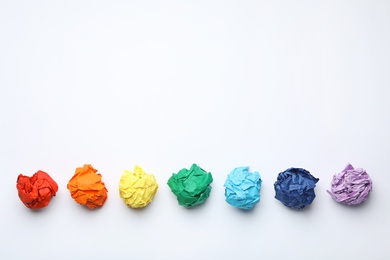 Photo of Colorful crumpled sheets of paper on white background, top view