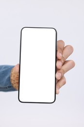 Man holding smartphone with blank screen on white background, closeup